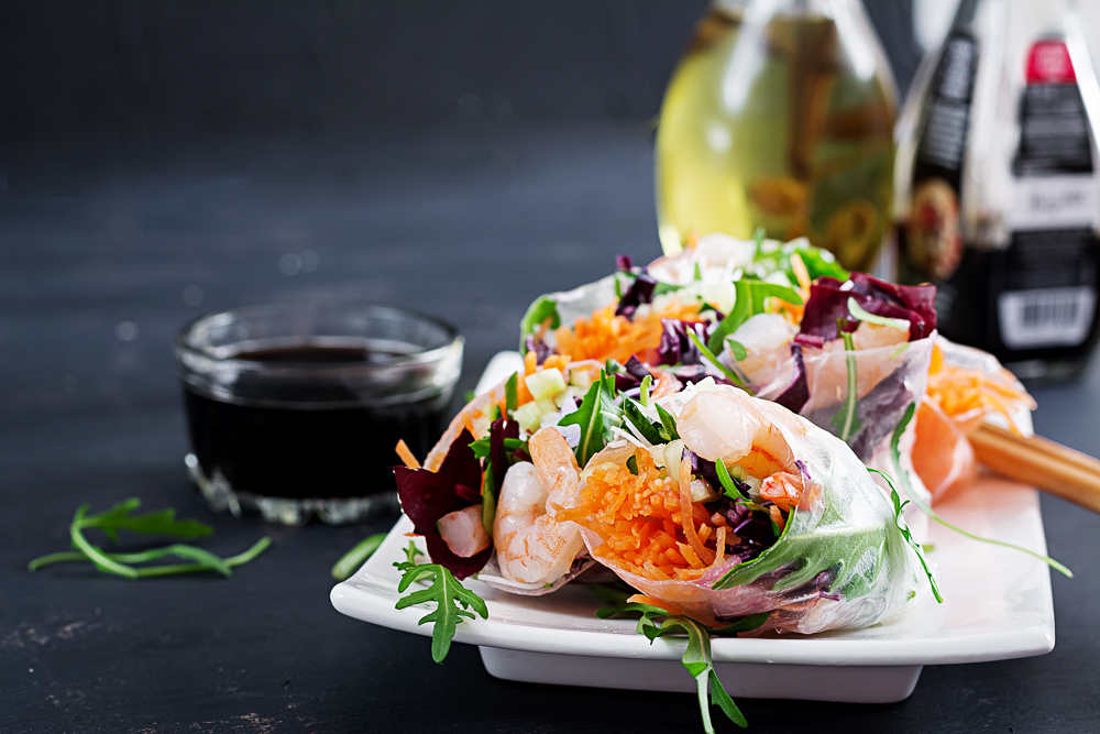 Vegetarian vietnamese spring rolls with spicy shrimps, prawns, carrot, cucumber, red cabbage and rice noodle. Seafood. Tasty meal. Copy space